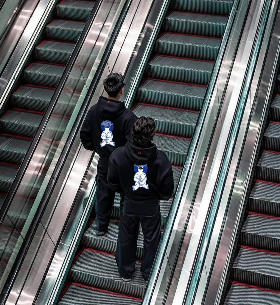 Two people in Mezy hoodies on an escalator